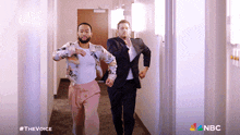two men are running down a hallway with nbc written on the bottom