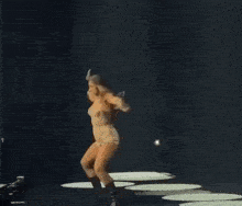 a woman is dancing on a stage holding a microphone .
