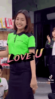 a woman in a green shirt with the words love u on it