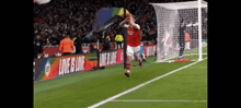 a soccer player is jumping in the air on a field with a banner that says love is love in the background