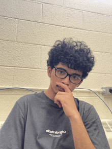 a young man wearing glasses and a t-shirt that says olbuz2 alrighto