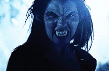 a close up of a woman 's face with fangs