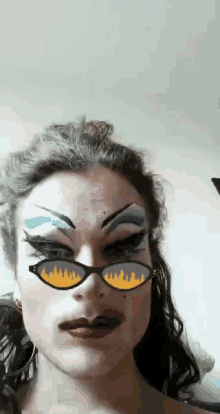 a close up of a woman wearing sunglasses with flames on them