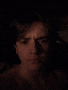 a man without a shirt is looking at the camera