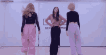 a group of women are dancing in front of a wall that says amber on it