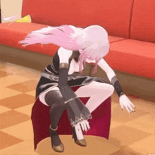 a cartoon girl is sitting on a red couch .