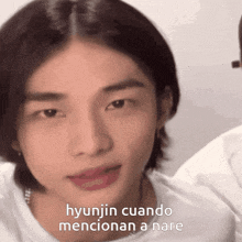 a close up of a person 's face with the words " hyunjin cuando mencionan a nare " below it