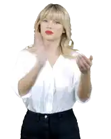 a blonde woman wearing a white shirt and black pants is making a hand gesture