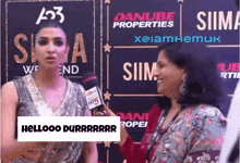 a woman talking into a microphone with a sign that says hellooo durrrrrr
