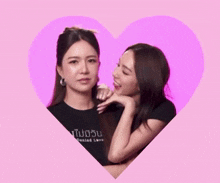 a woman wearing a black shirt that says denied love licks another woman 's face