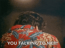 a man in a red shirt is talking to another man .