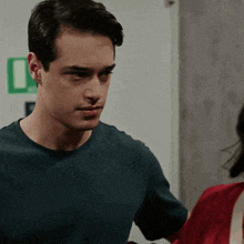 a man in a blue shirt looks at a woman in a red dress