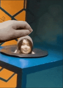 a person is putting a picture of a woman on a blue table