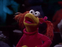 a stuffed animal with big eyes and red pigtails