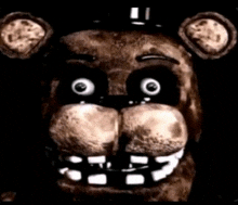 a close up of the face of freddy fazbear from five nights at freddy 's in the dark .