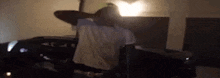 a man is sitting in a chair in a dark room with his hands behind his head .