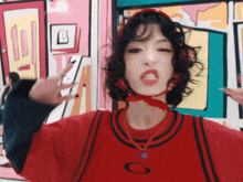 a woman wearing a red shirt with a g on it
