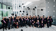 a group of graduates are throwing their hats in the air