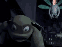 a man is standing next to a turtle and a frog in a dark room .
