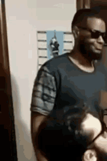 a man wearing sunglasses and a black shirt is standing next to another man .