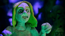 a clay sculpture of a woman with green hair and a purple background