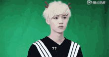 a young man with white hair and antlers on his head is wearing a black and white shirt .