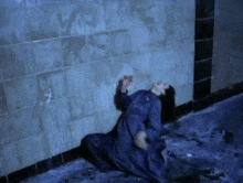 a woman in a blue dress is crawling on the floor in a dark room .