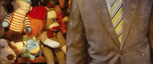 a man in a suit and tie is standing in front of a shelf full of stuffed animals