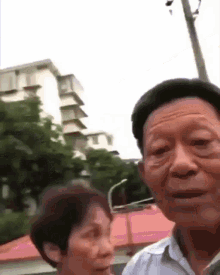 a man and a woman are standing next to each other with a building in the background