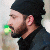 a man with a beard wearing a black hat