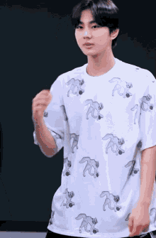 a young man wearing a white t-shirt with a pattern of foxes on it