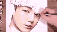a person is drawing a man 's face with colored pencils