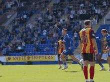 a shyte shifters sign is behind a group of soccer players