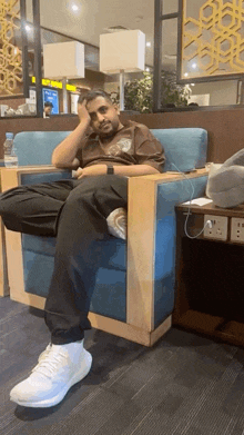 a man sits in a chair with a bottle of water next to him