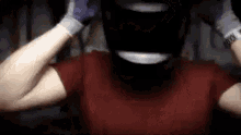 a man wearing a helmet and gloves is making a face .