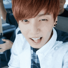 a close up of a young man with red hair sticking his tongue out