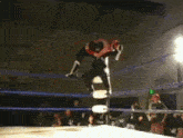 a wrestler in a ring with a green exit sign