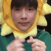 a young man wearing a yellow sun hat is making a funny face .