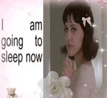 a girl with a bow in her hair is next to a sign that says i am going to sleep now