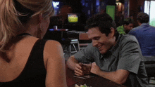 a man and a woman are sitting at a table in front of a television