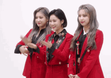 three women in red jackets are standing next to each other and smiling