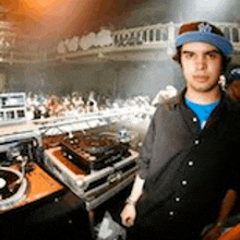 a man is standing in front of a dj booth .