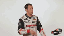 a man wearing a jacket that says discount is standing in front of a nascar logo
