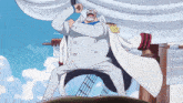 a man in a white suit and cape is standing on a boat with his fist in the air