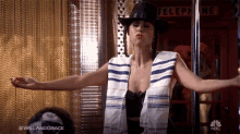 a woman in a cowboy hat is standing in front of a telephone booth with her arms outstretched