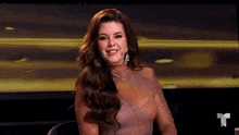 a woman in a pink dress is sitting in front of a screen .