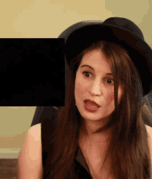 a woman wearing a black hat and a black dress