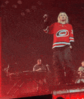 a woman wearing a red and black jersey with the number 5 on it