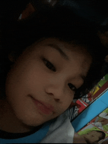 a close up of a child 's face with a picture of a baby in the background