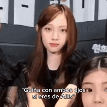 a group of girls are standing next to each other and one of them is talking in a foreign language .